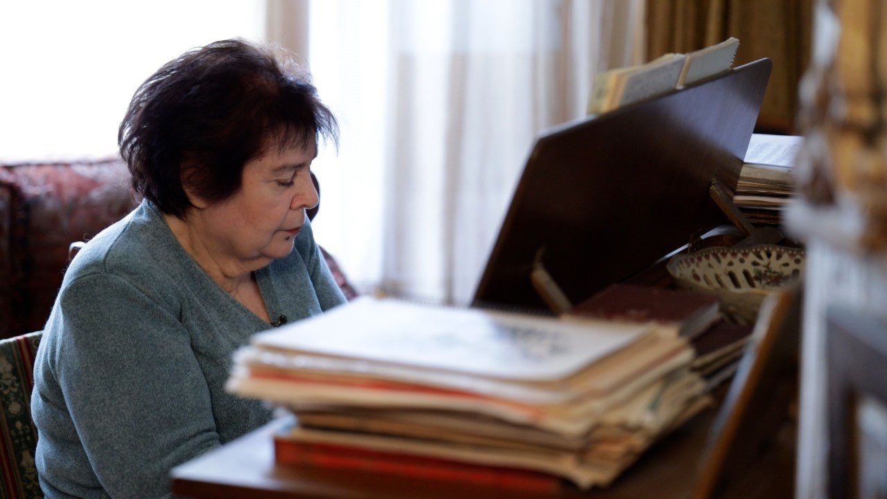 <p>ნუნუ გაბუნია – კომპოზიტორი, რომლის მელოდიებმაც არაერთი თაობა აღზარდა. მისი მუსიკით მომღერლები პოპულარული ხდებოდნენ, ქართული სიმღერა კი ამაღლებული. მისი ნაწარმოებები მელოდიურობის, სინატიფისა და შინაგანი დრამატურგიის ნაზავია – მუსიკა, რომელიც არამხოლოდ ჟღერს, არამედ ადამიანში რაღაცას ცვლის.</p><p>სწორედ ამიტომ, “Front News საქართველოს” ვიდეო პროექტი “ადამიანები ისტორიით“ მორიგ სტუმრად მასპინძლობს ნუნუ გაბუნიას – კომპოზიტორს, რომელიც დიდი ხანია, ქართული მუსიკალური კულტურის ნაწილი გახდა.</p><p>ვიდეო ინტერვიუში ნუნუ გაბუნია იხსენებს თავის გზას, გვიზიარებს მტკივნეულ და სასიამოვნო მომენტებს, შთაგონებას და ადამიანებს, რომლებმაც მისი შემოქმედება განსაზღვრეს.</p><p>ერთ-ერთი გამორჩეული ისტორიაც სწორედ შთაგონებას უკავშირდება: ერთ დღეს, ლენინგრადის ოპერის თეატრის სოლისტ ბაგაჩოვას შესრულებით, “Ave Maria“ მოისმინა. ის შესრულება იმდენად ემოციური აღმოჩნდა, რომ გაბუნიამ გადაწყვიტა, შეექმნა საკუთარი “Ave Maria“. ასე დაიბადა კომპოზიცია, რომელმაც მალევე მუსიკალური სამყარო დააინტერესა.</p><p>დღეს მსოფლიოში 5000-მდე Ave Maria არსებობს. მათ შორის კი მხოლოდ ერთეულები შევიდნენ უნიკალურ საერთაშორისო ალბომში, სადაც 17 მამაკაცი კომპოზიტორის გვერდით ნუნუ გაბუნიას Ave Maria-ც არის წარმოდგენილი. ის ერთადერთი ქალია ამ კოლექციაში და ისეთი კომპოზიტორების გვერდითაა, როგორებიც არიან: ვერდი, შუბერტი, კაჩინი და სხვა.</p><p>პირველად მისი Ave Maria თბილისის ოპერის თეატრის სოლისტმა ნაირა გლუნჩაძემ შეასრულა. შემდგომ კი ეს ნაწარმოები მრავალმა ცნობილმა მომღერალმა გააჟღერა სცენაზე – სიყვარულით, სითბოთი და პატივისცემით კომპოზიტორის მიმართ.</p><p>ინტერვიუში ნუნუ გაბუნია ასევე იხსენებს ახლო მეგობარს – ეთერ კაკულიას, რომელსაც მრავალი სიმღერა შეასრულებინა. მათ მეგობრობას მუსიკა ამყარებდა, თუმცა მოგონებები სცენას გაცდა – ბაქოში გადახდენილი ერთ-ერთი ისტორია, რომელიც თენგიზ სულხანიშვილთან ერთად გაიარა, დღემდე ღიმილით ახსენდება.</p><p>ნუნუ გაბუნიას ამბავი არის ადამიანის ისტორია, რომელიც მელოდიად გადაიქცა.</p><p>იხილეთ ვიდეო და მოუსმინეთ ქართულ მუსიკას – ისეთს, როგორიც ის ნუნუ გაბუნიასთან ერთად გახდა: ნამდვილი, სულიერი და სამარადჟამო.</p><p></p>